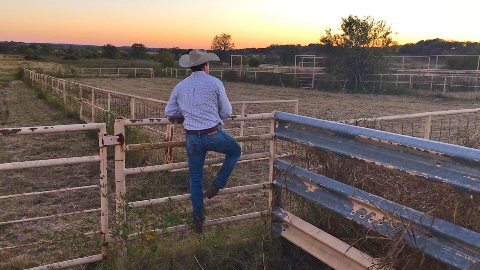 Photo of rancher climbing fence